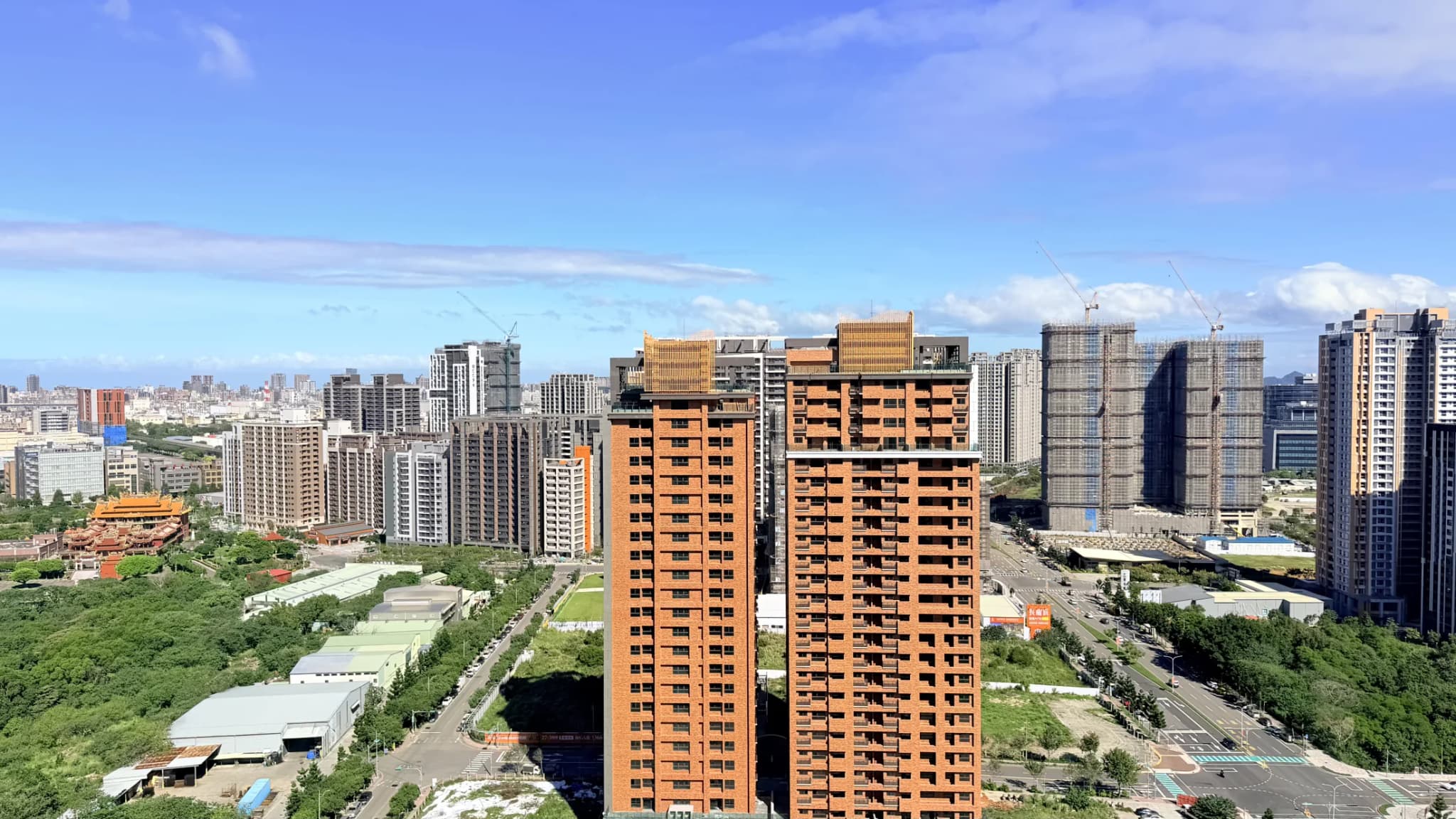 A7 重劃區日間城市全景,可見住宅、道路、既有聚落與持續開發街廓